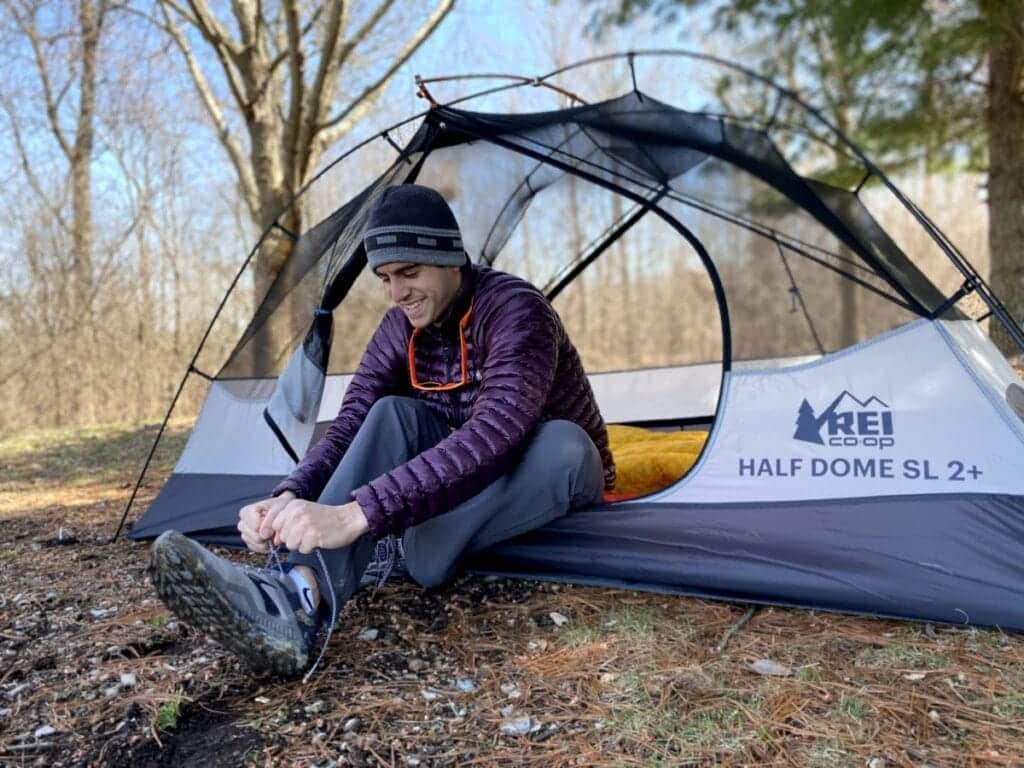 person is tying shoe laces while sitting in the REI Co op Quarter Dome SL