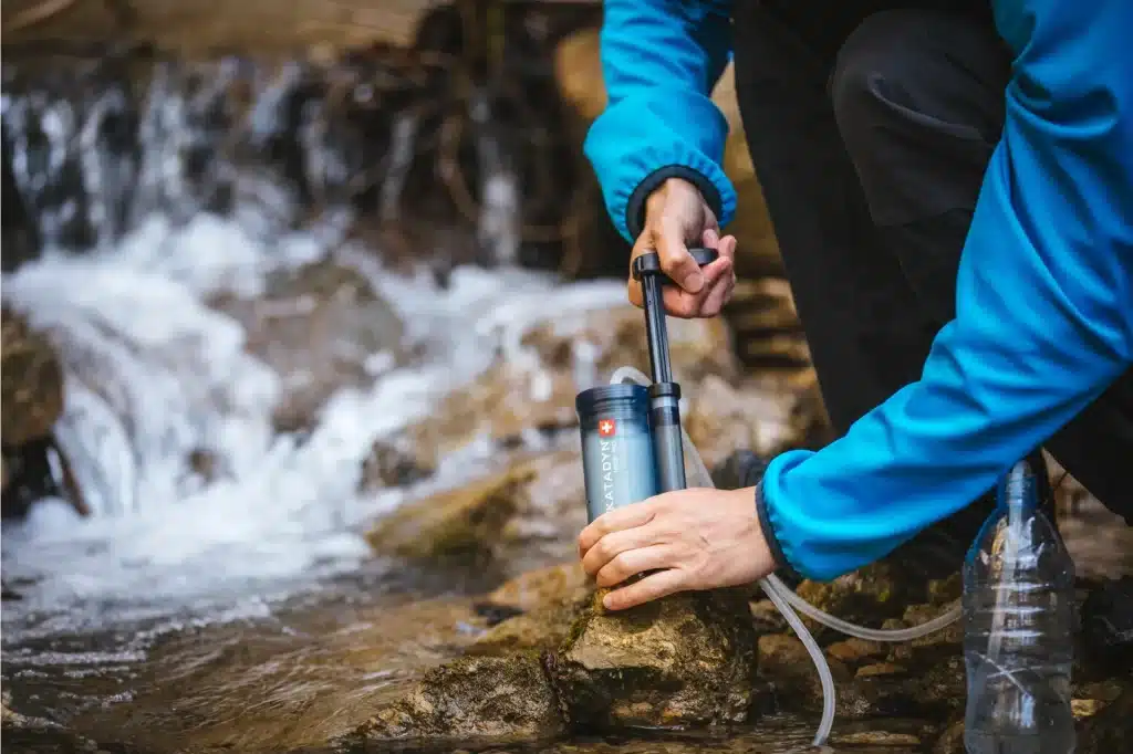 a man filtering water using Katadyn Hiker Pro filter