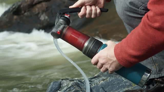 a man using MSR Guardian for water filtration