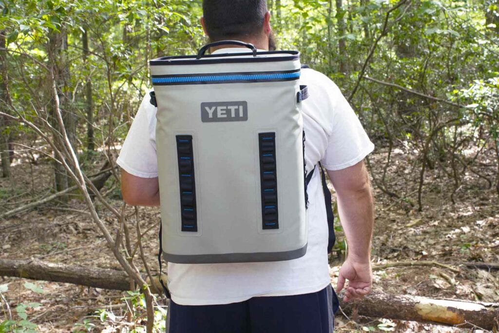 a man carrying his YETI hooper backflip on his back 