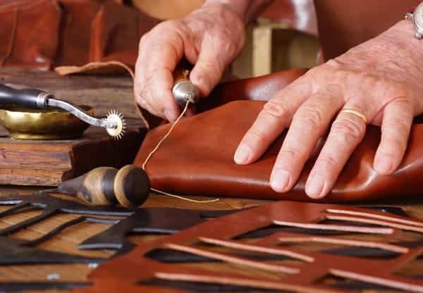 a man fixing leather bag straps 