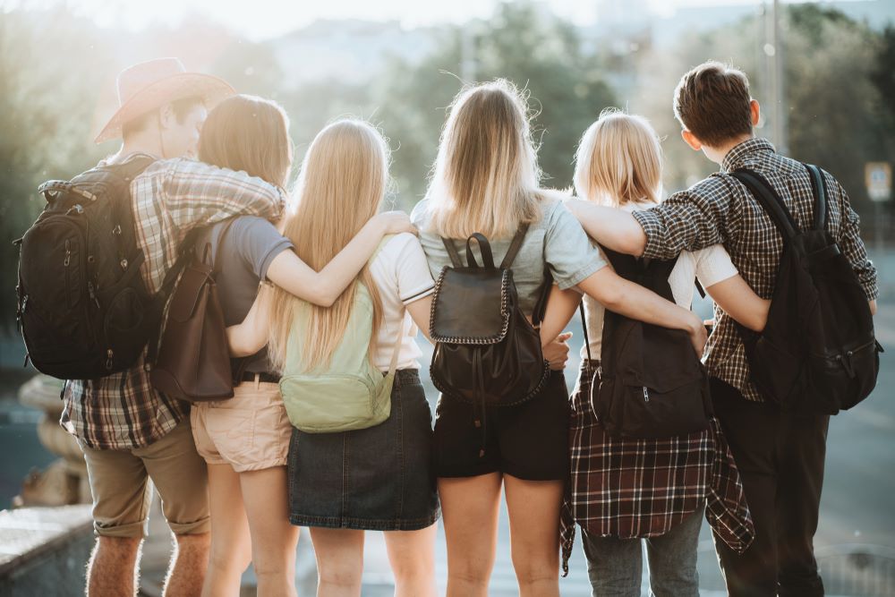 Young people with backpacks standing close