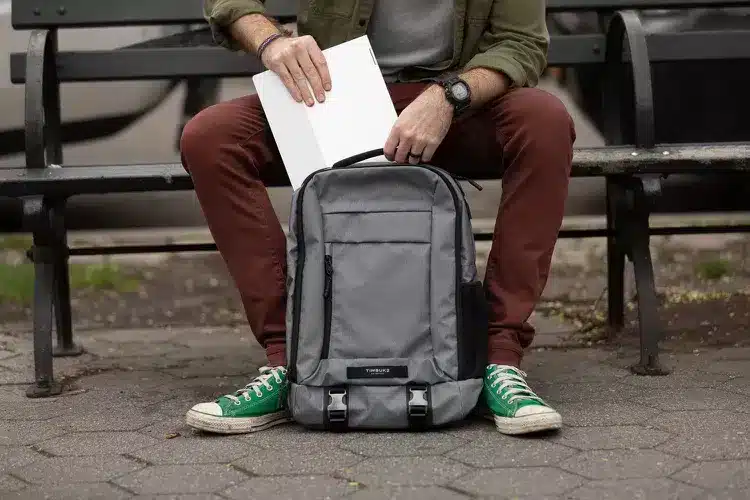 a man putting laptop in his Timbuk Authority Laptop backpack 