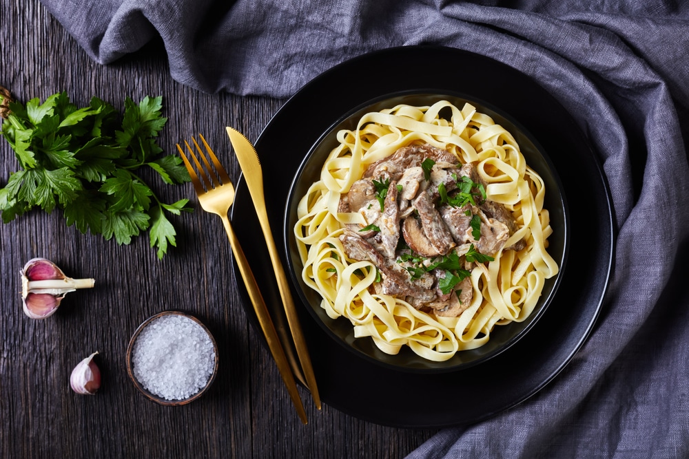 Beef Stroganoff Cooked With Sour Cream Mushrooms Sauce in a black bowl