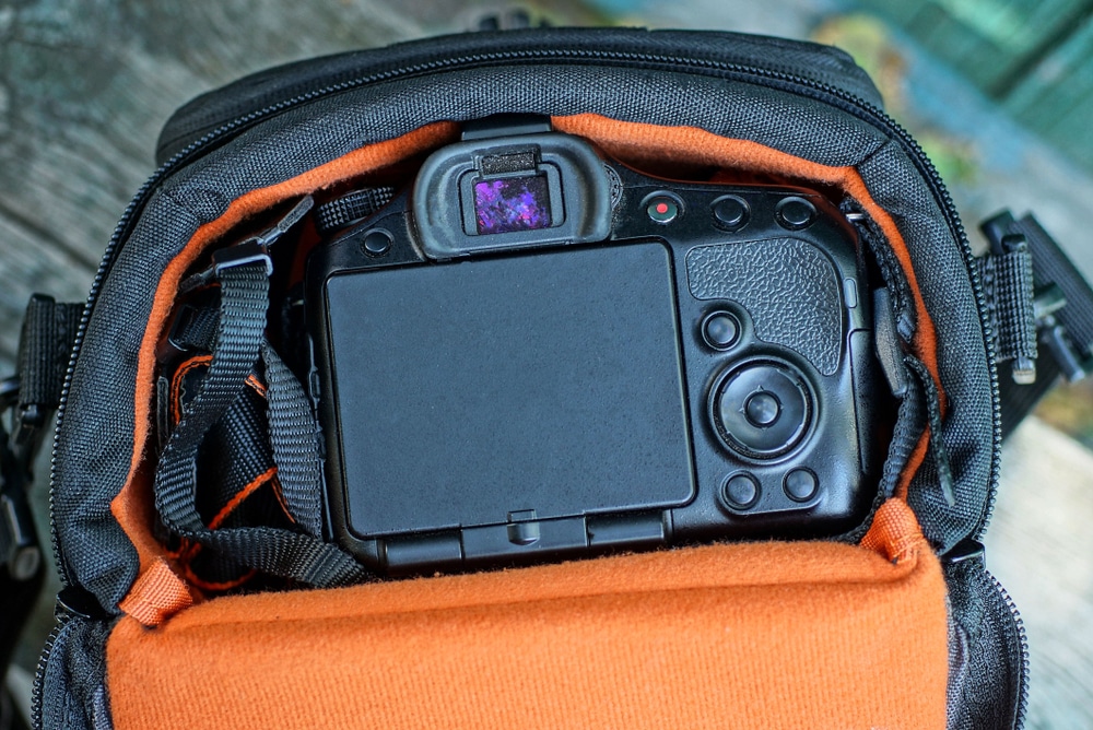 One Orange Bag With A Black Camera On A Gray