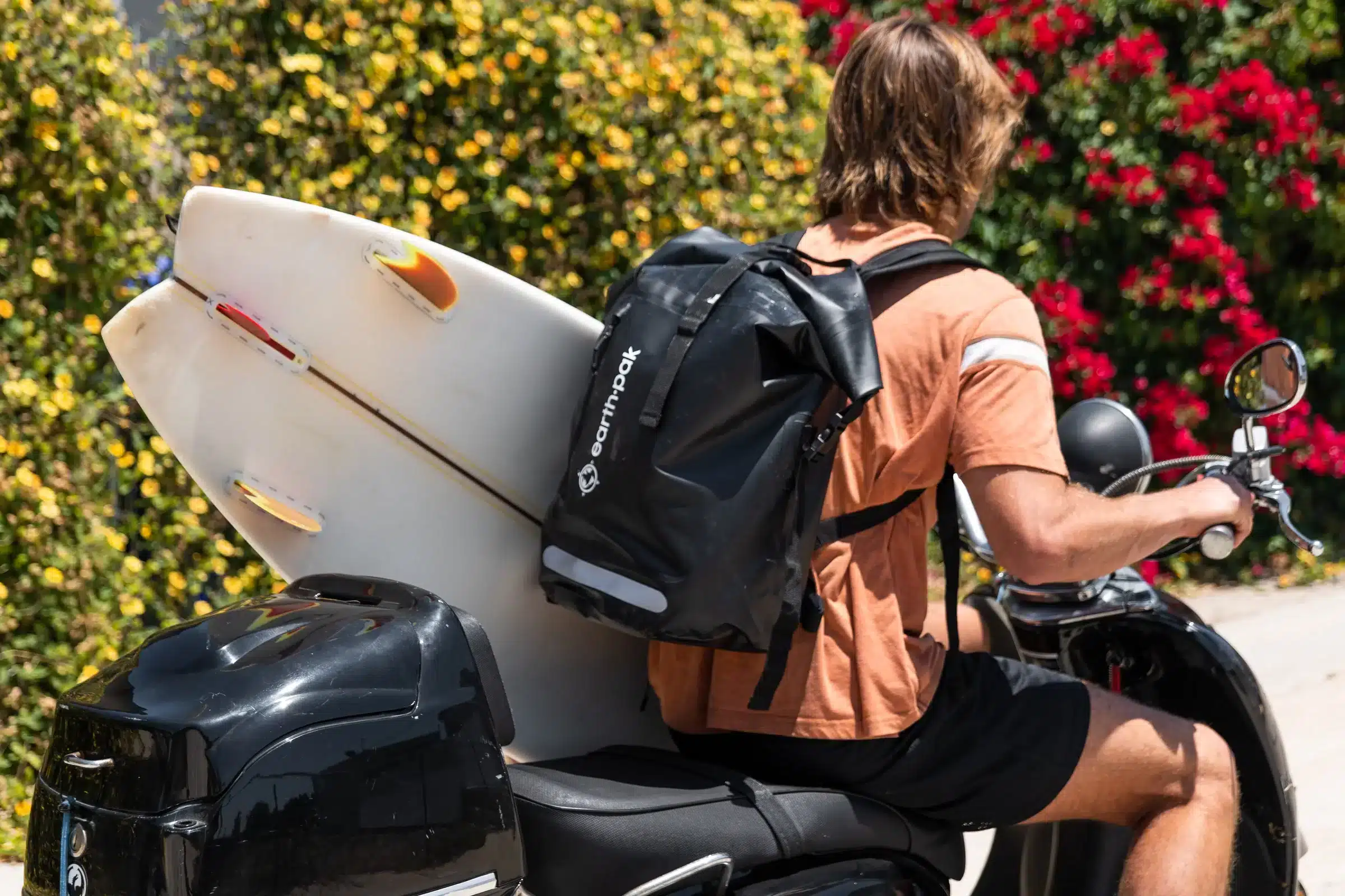 a biker sitting on his bike wearing earth pak waterproof backpack