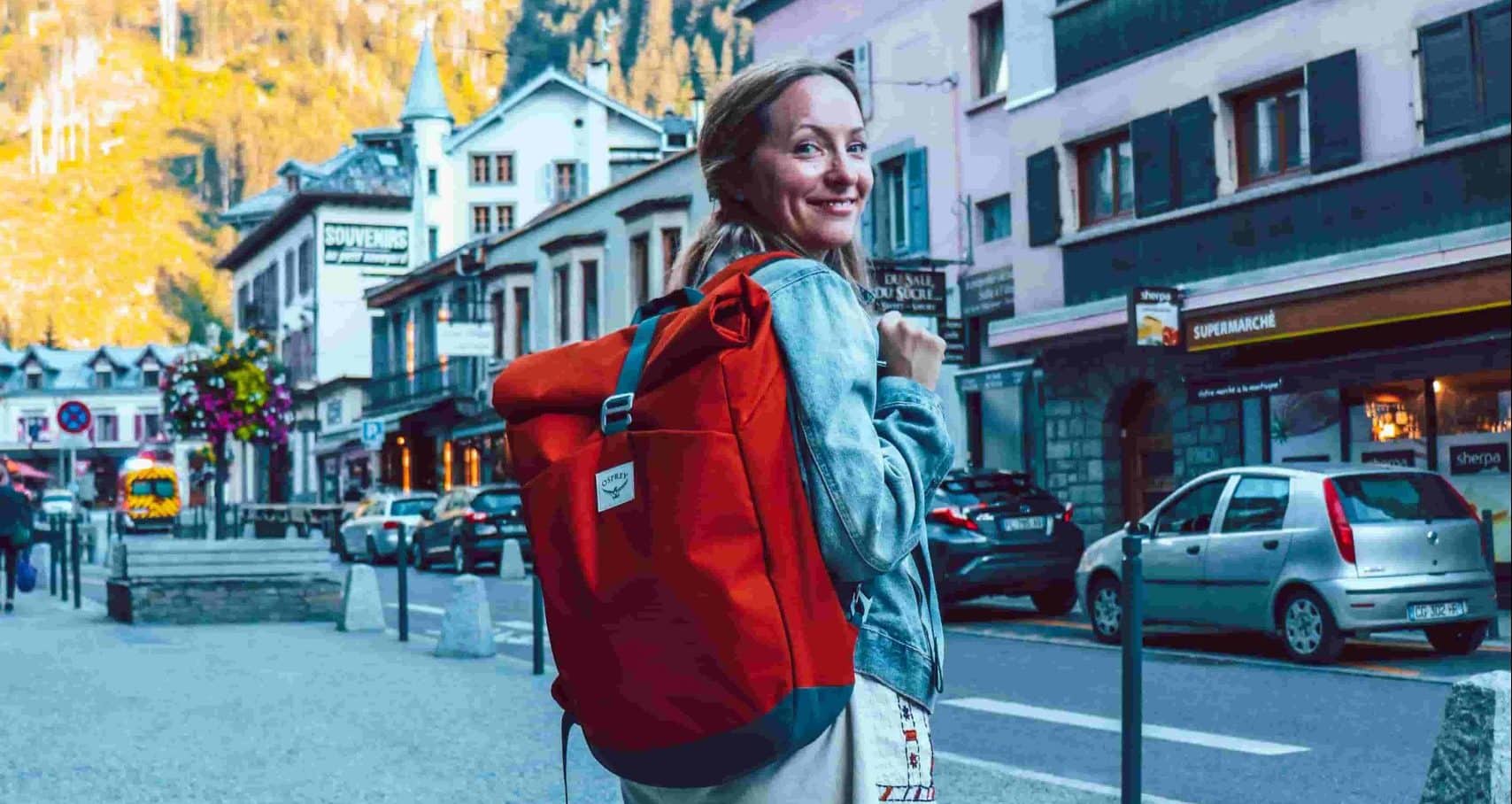 a lady carrying Osprey Arcane Roll Top Waterproof Backpack  standing on the road