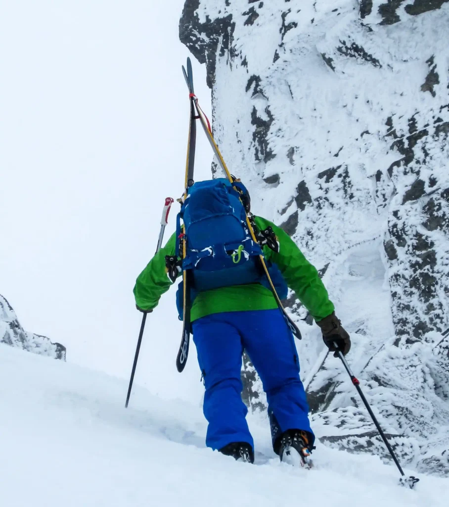 a man climbing a mountain wearing Osprey Kamber