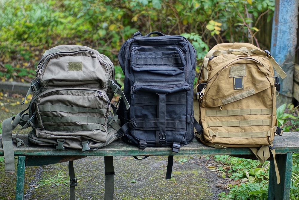 A Row Of Three Large Army Green Black Backpacks Stand