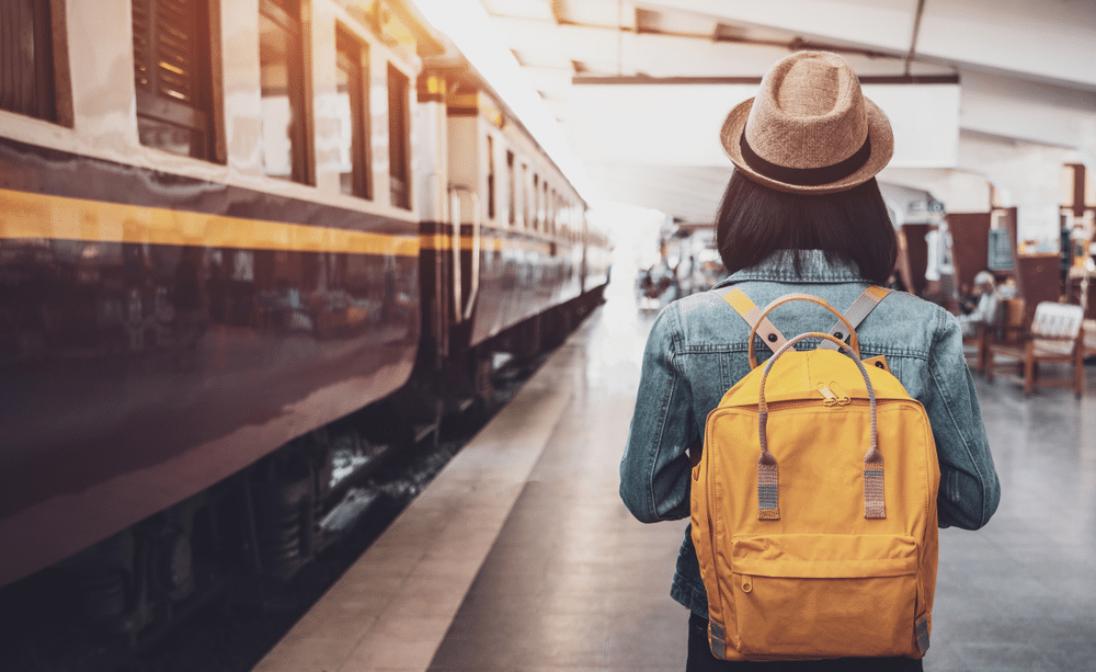 woman traveler with backpack in the railway Backpack and hat at the train station