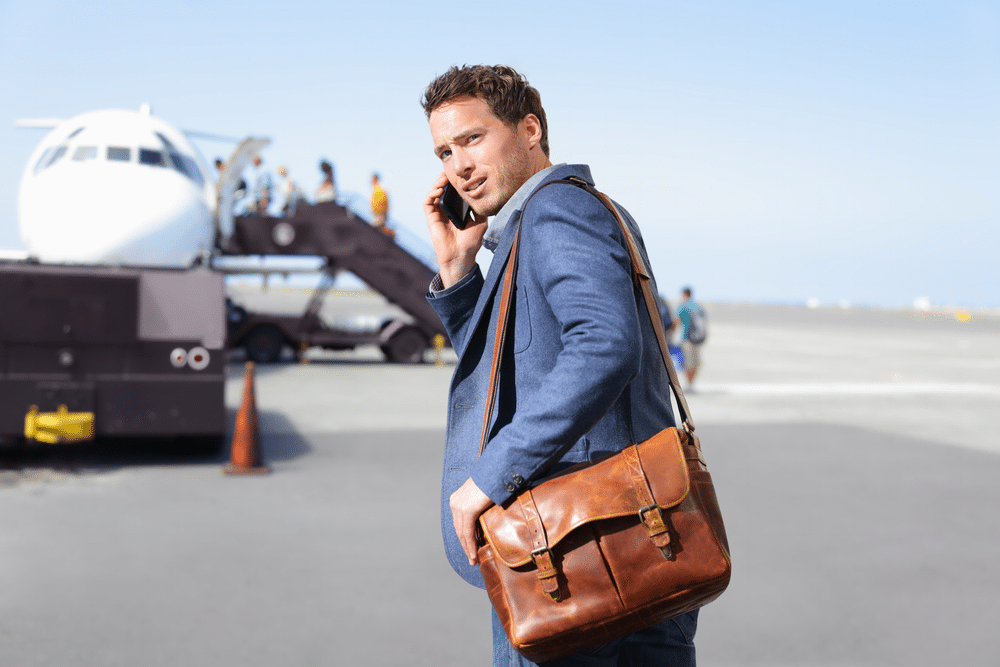 young man wearing messenger bag on airport