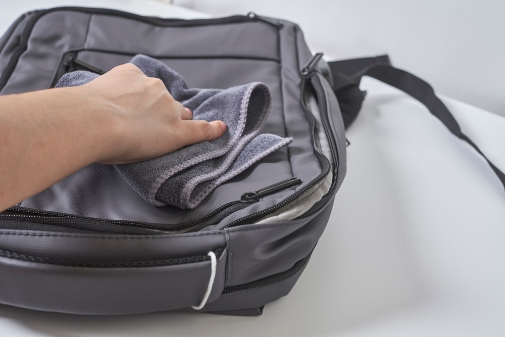 Cleaning Backpack With Washcloth A Person Wipes Off Dirt Or