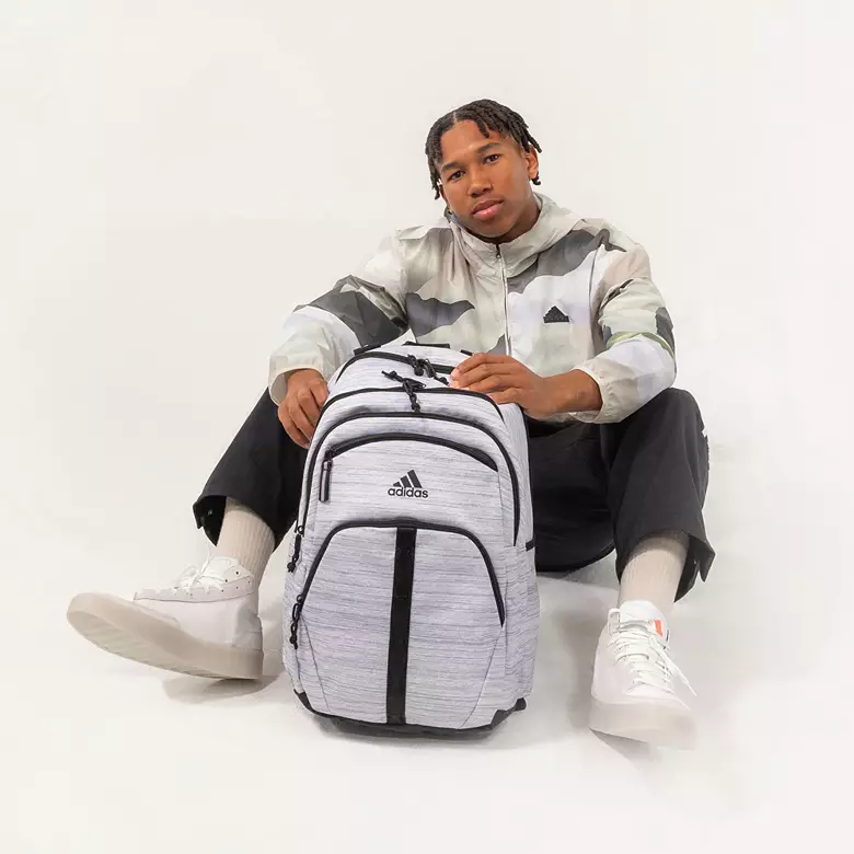 a boy holding adidas prime backpack a boy holding adidas prime backpack