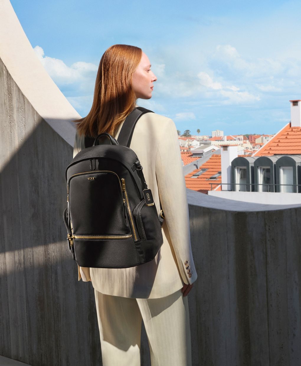 side pose of a woman carrying celina TUMI backpack side pose of a woman carrying celina TUMI backpack