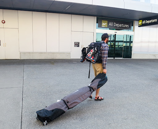 back of a boy dragging a ski bag back of a boy dragging a ski bag