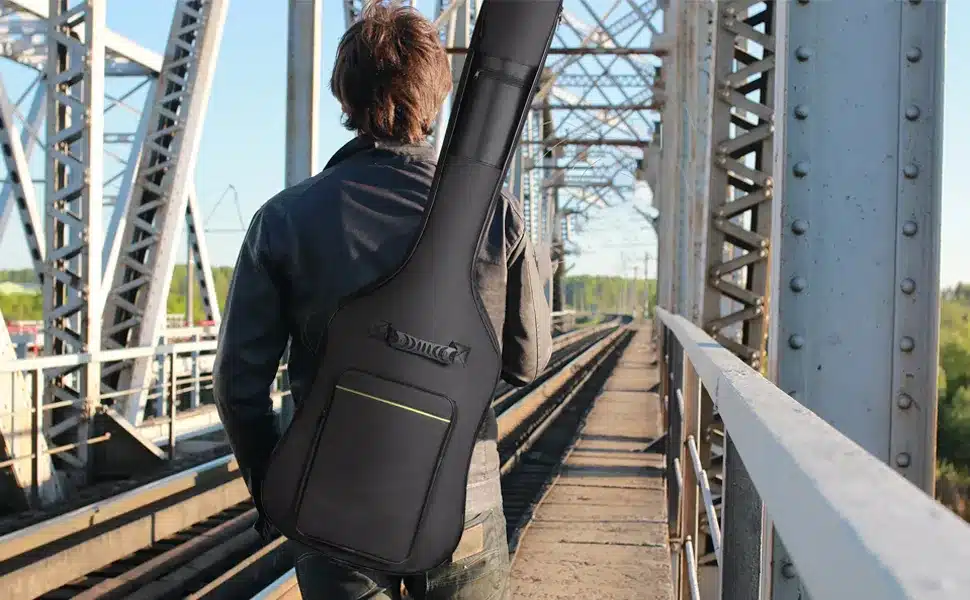 back of a guy wearing a black guitar case