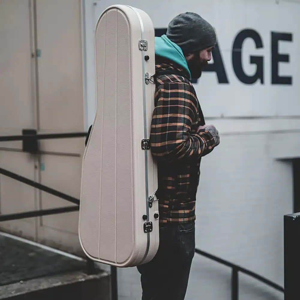 side pose of a boy wearing a guitar case side pose of a boy wearing a guitar case
