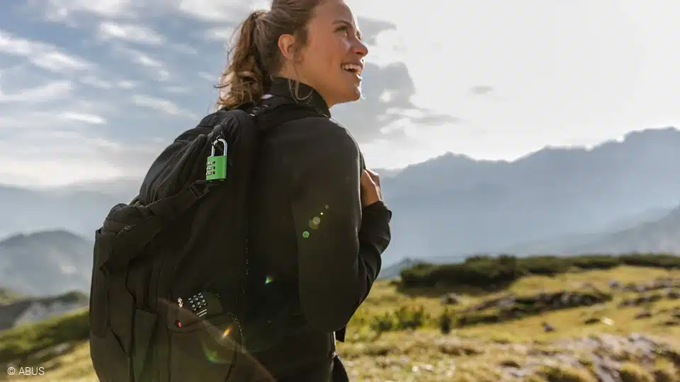 a female traveller smiling wearing a backpack with lock